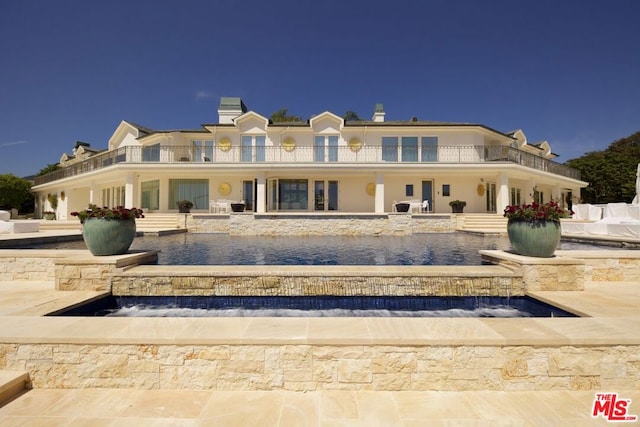 rear view of property featuring a balcony