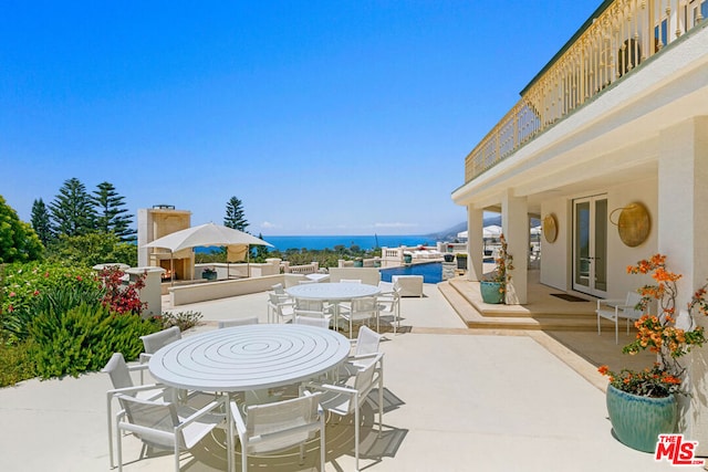 view of patio with a water view and french doors