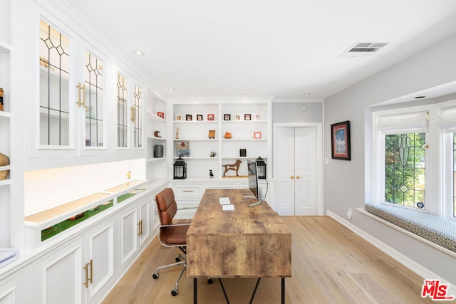 home office with light hardwood / wood-style floors