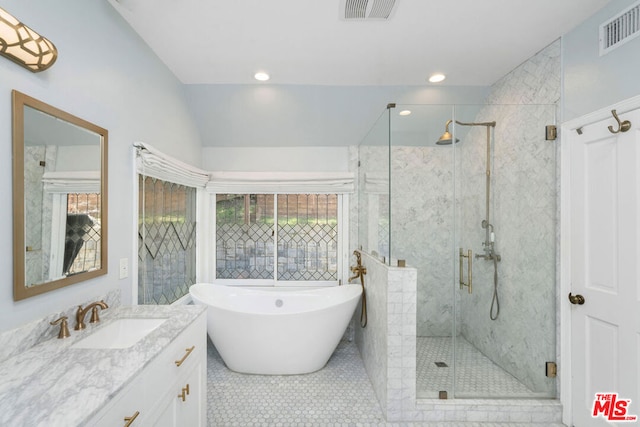 bathroom featuring tile patterned flooring, vanity, lofted ceiling, and shower with separate bathtub