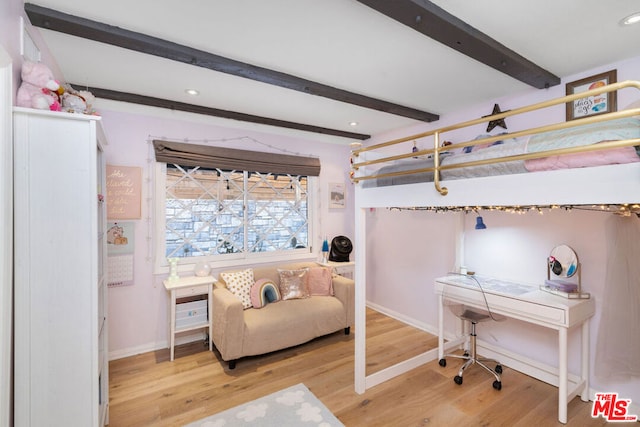 bedroom featuring hardwood / wood-style floors and beam ceiling