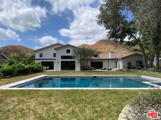 view of pool featuring a mountain view and a yard