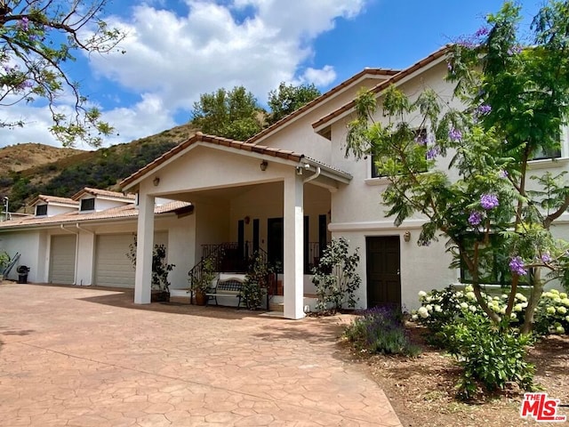 mediterranean / spanish-style home with a mountain view and a garage