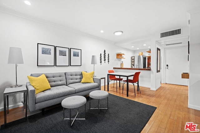 living room featuring hardwood / wood-style flooring and ornamental molding