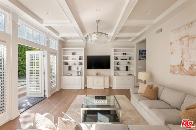 living room with coffered ceiling, built in shelves, light wood-type flooring, beamed ceiling, and a chandelier