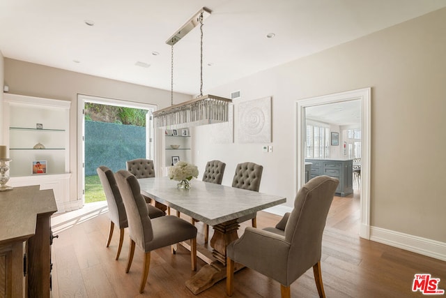 dining area with built in features and hardwood / wood-style flooring