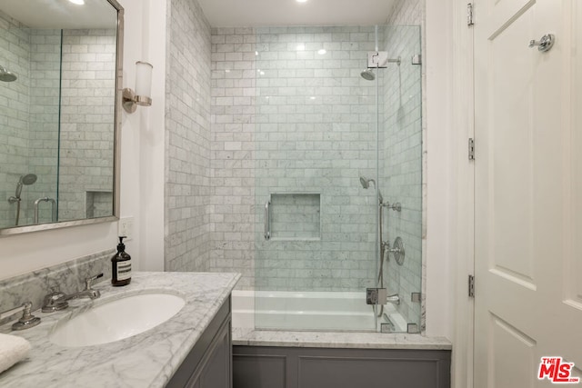 bathroom featuring vanity and bath / shower combo with glass door