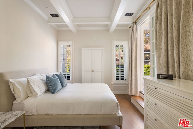 bedroom featuring beamed ceiling, wood-type flooring, multiple windows, and coffered ceiling