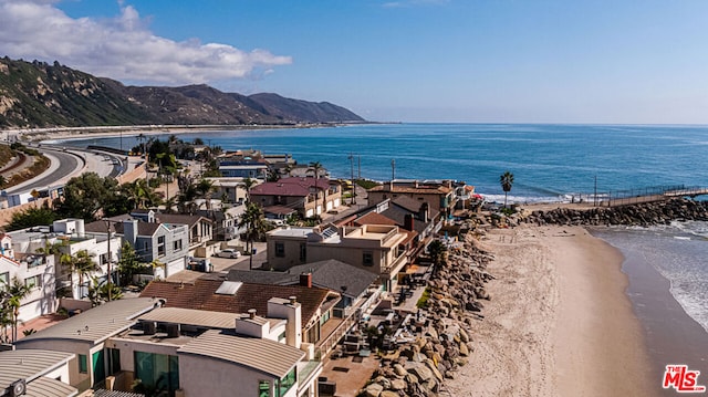 birds eye view of property featuring a water and mountain view and a beach view