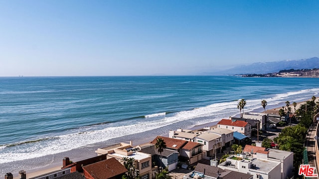 drone / aerial view featuring a water view and a view of the beach