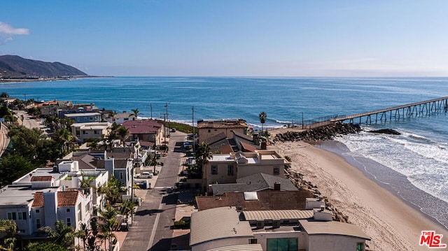 birds eye view of property with a water view and a beach view