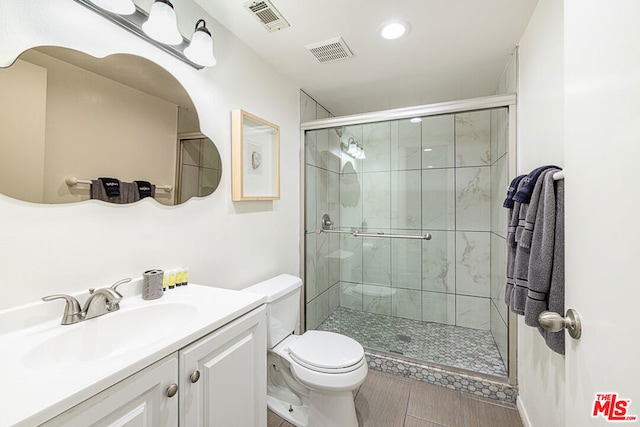 bathroom featuring walk in shower, vanity, and toilet