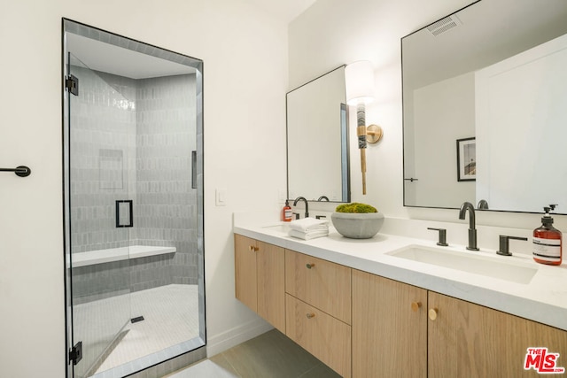 bathroom with vanity, tile patterned floors, and a shower with door