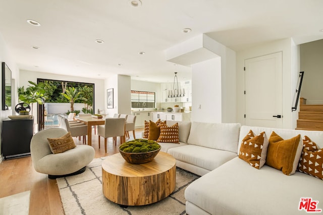 living room with a chandelier and light hardwood / wood-style flooring