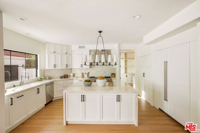 kitchen with white cabinets, pendant lighting, stainless steel dishwasher, and sink