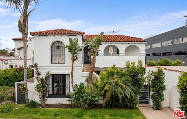 mediterranean / spanish home with a front lawn