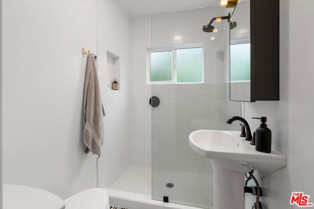 bathroom with tiled shower and toilet