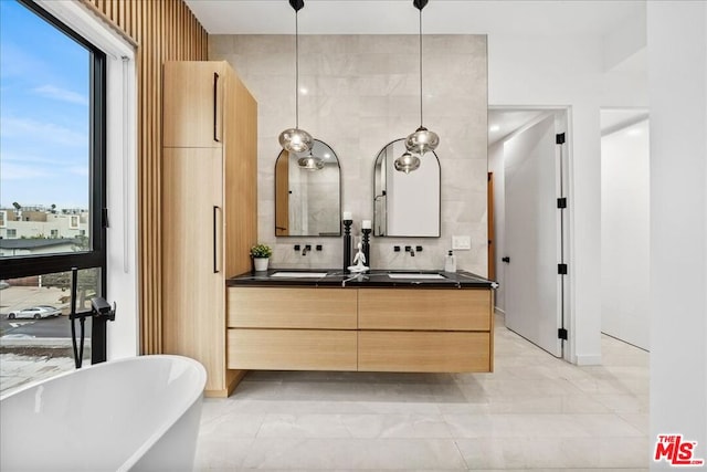 bathroom with a tub to relax in, backsplash, a wealth of natural light, and vanity