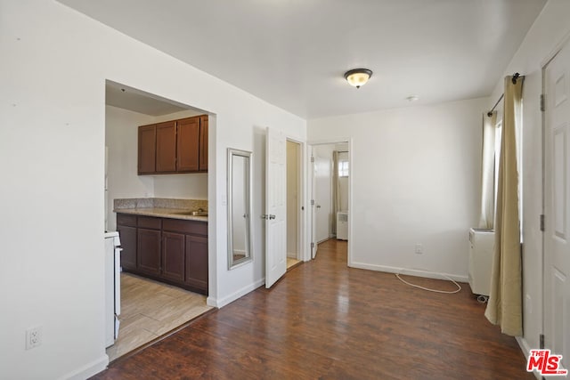 kitchen featuring dark brown cabinetry, dark hardwood / wood-style flooring, and range