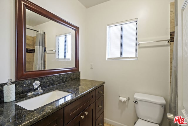 bathroom featuring a shower with curtain, vanity, and toilet