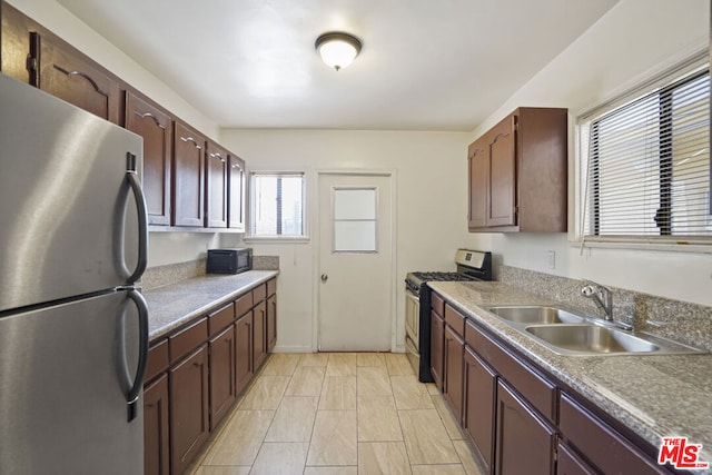 kitchen with dark brown cabinets, sink, and appliances with stainless steel finishes