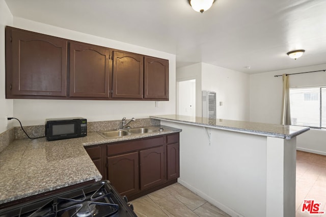 kitchen featuring kitchen peninsula, sink, dark brown cabinets, and range