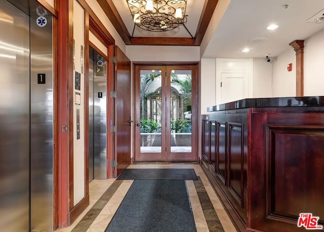 entryway with elevator, ornamental molding, and a notable chandelier