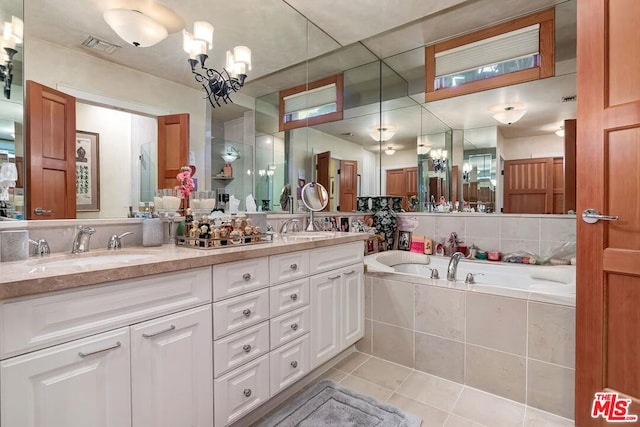 bathroom featuring vanity, tile patterned floors, and tiled tub