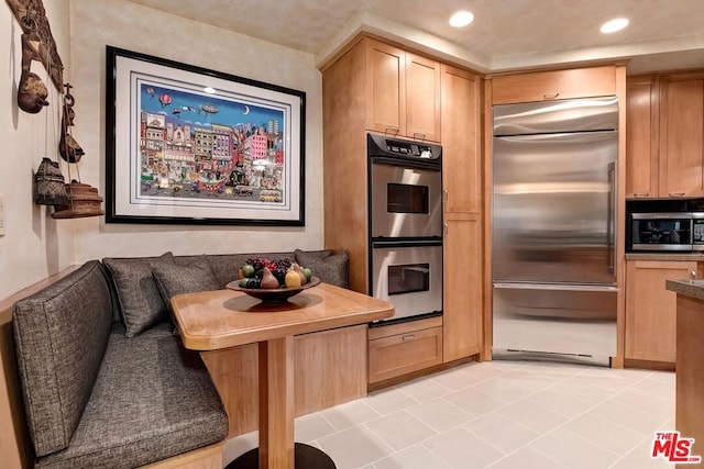 kitchen with light tile patterned flooring and appliances with stainless steel finishes