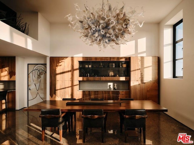 bar featuring a high ceiling and a chandelier