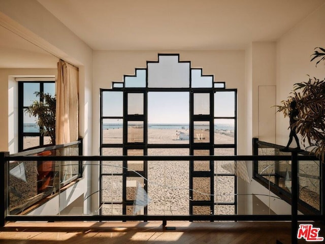 interior details featuring wood-type flooring, a water view, and french doors