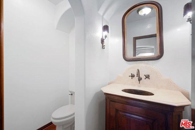 bathroom with decorative backsplash, vanity, and toilet