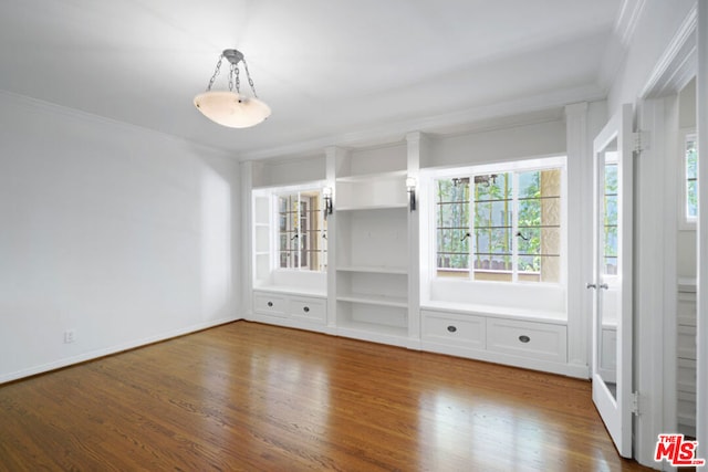 unfurnished living room with ornamental molding and hardwood / wood-style flooring