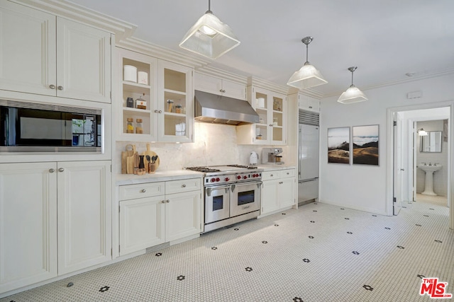 kitchen featuring built in appliances, white cabinets, hanging light fixtures, and ornamental molding