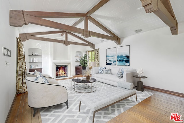 living room with hardwood / wood-style flooring, built in shelves, vaulted ceiling with beams, and wood ceiling