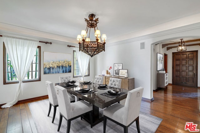 dining space featuring dark wood-type flooring and an inviting chandelier