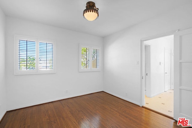 unfurnished room with dark hardwood / wood-style flooring