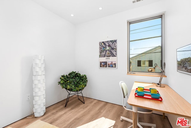 home office with light hardwood / wood-style floors