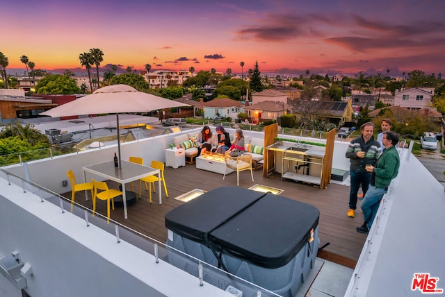 deck at dusk with a covered hot tub