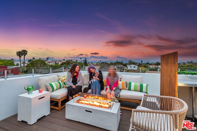 deck at dusk featuring an outdoor fire pit