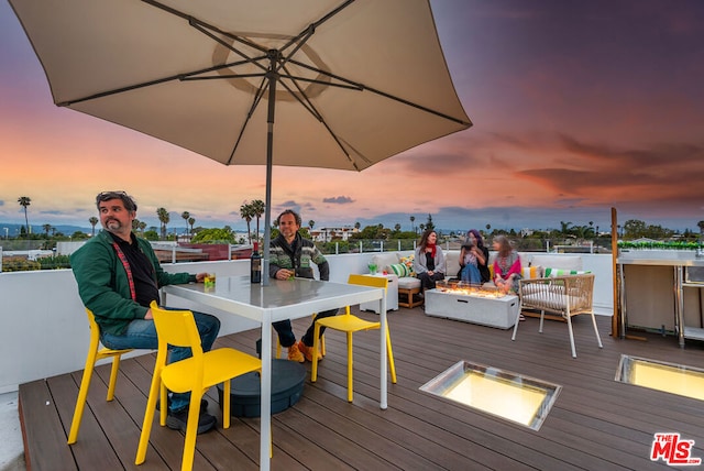 deck at dusk with a fire pit