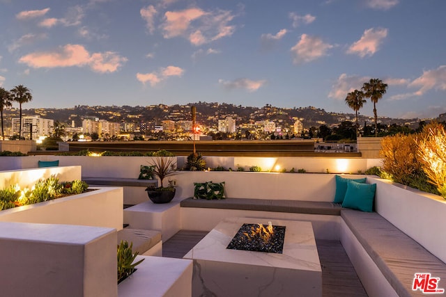 patio terrace at dusk featuring an outdoor fire pit