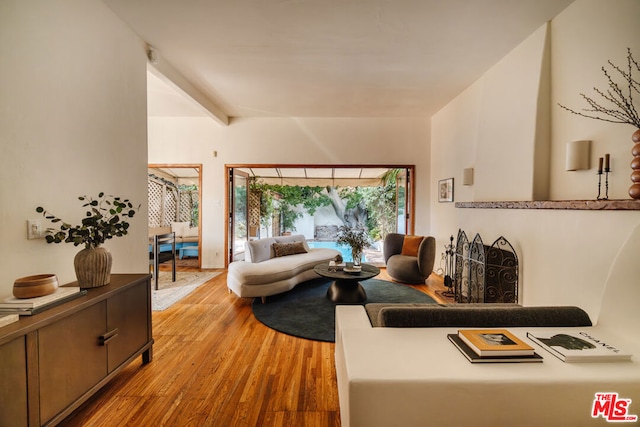 living room with light hardwood / wood-style floors and beam ceiling