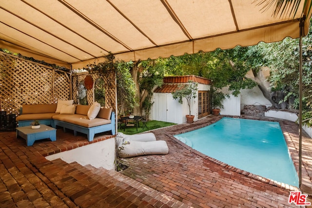 view of pool featuring a patio, an outdoor hangout area, and a shed