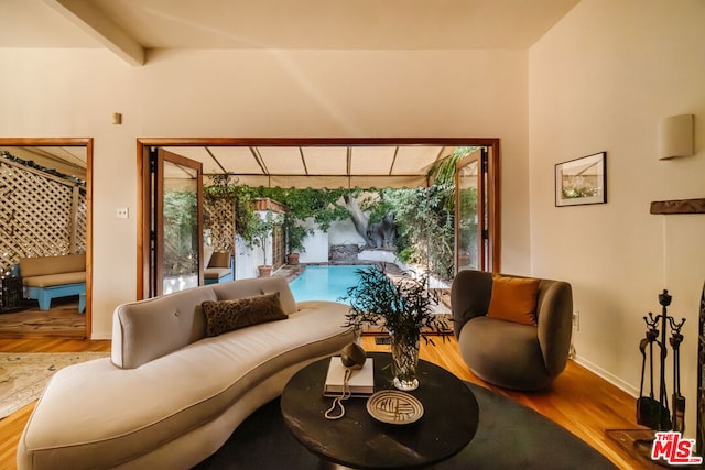 interior space featuring beam ceiling and light hardwood / wood-style flooring