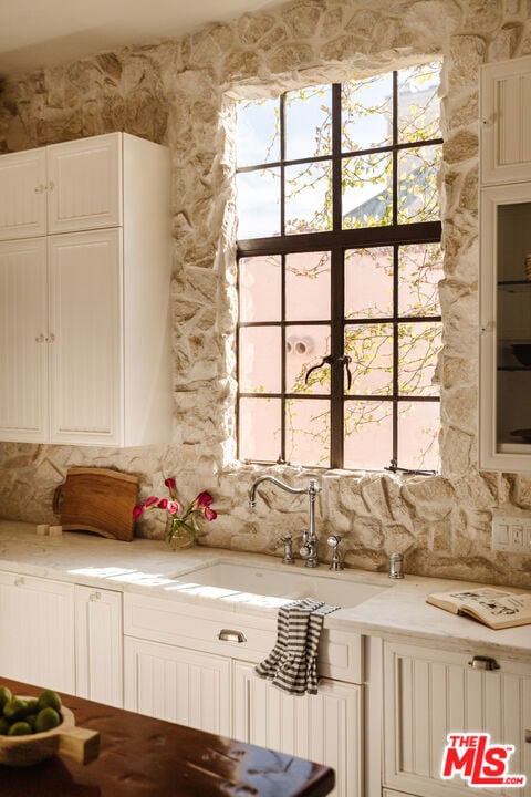 kitchen featuring white cabinetry and sink