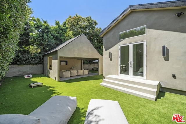 rear view of house with a lawn and french doors