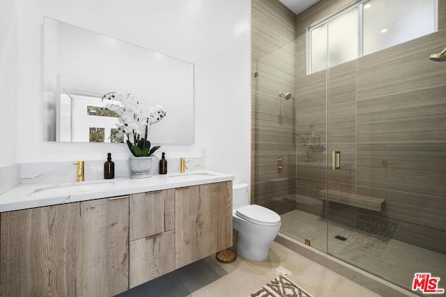 bathroom with tile patterned flooring, vanity, a shower with shower door, and toilet