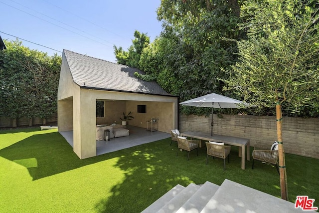 back of house featuring a lawn and a patio