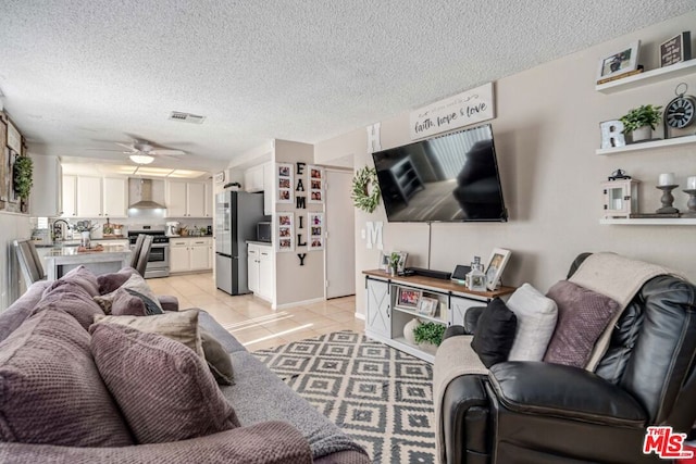 tiled living room featuring ceiling fan and a textured ceiling